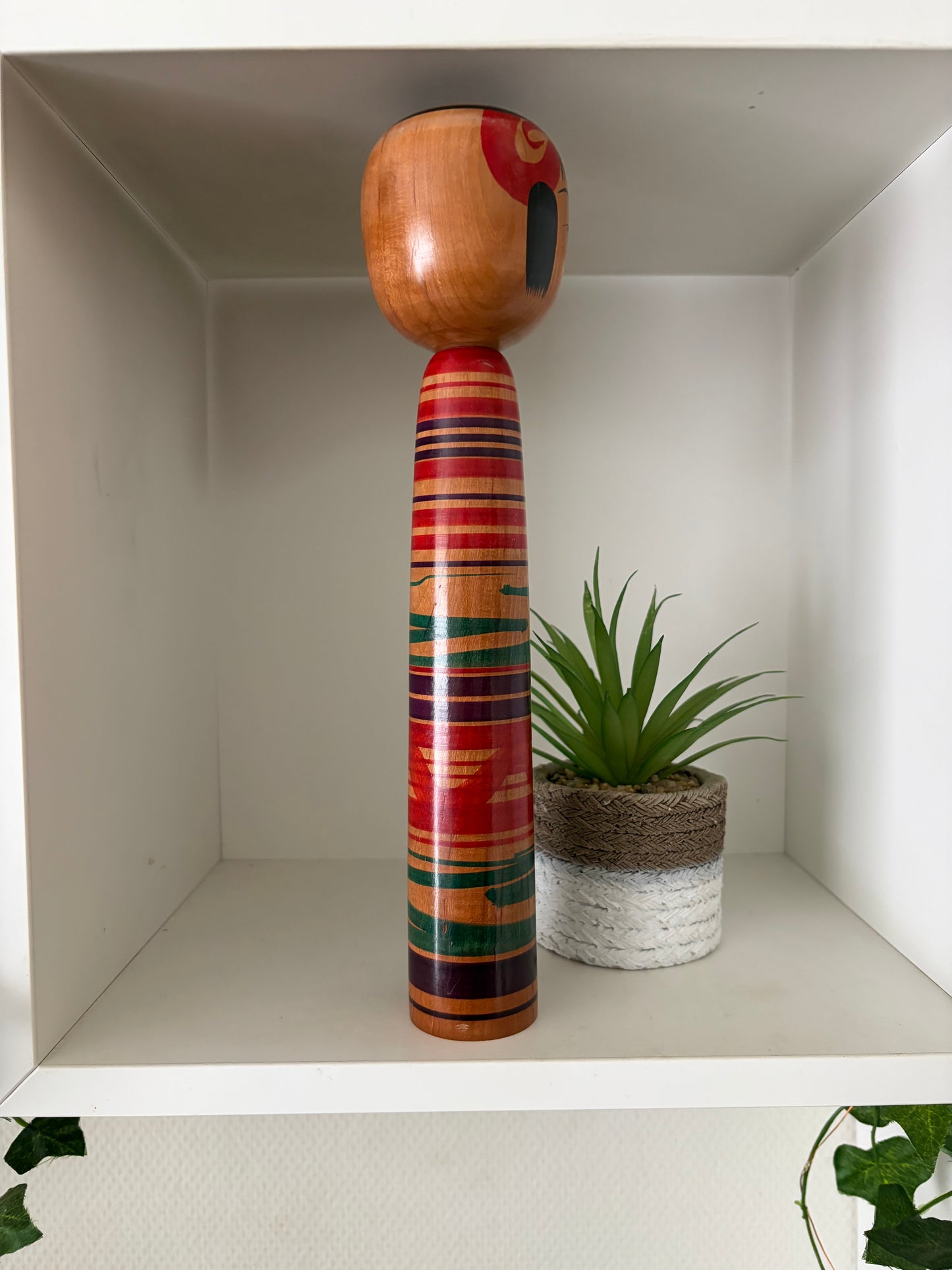 Vintage traditional Tsuchiyu kokeshi with striped design.