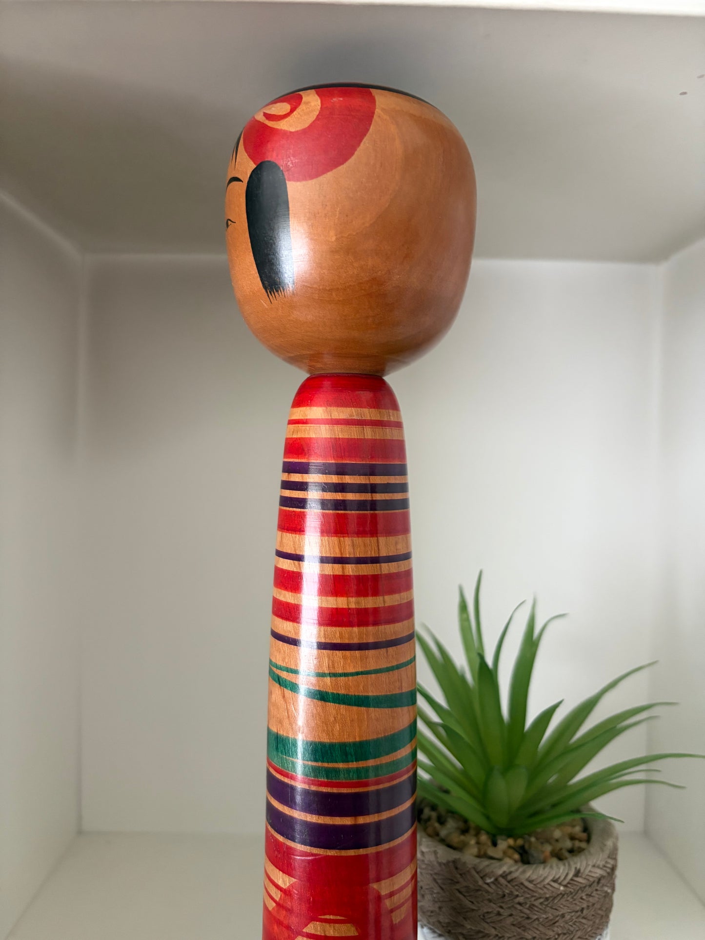 Vintage traditional Tsuchiyu kokeshi with striped design.