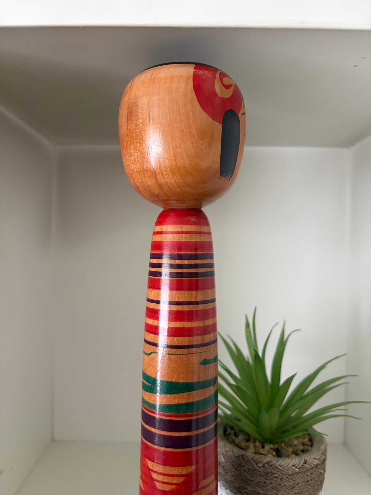 Vintage traditional Tsuchiyu kokeshi with striped design.